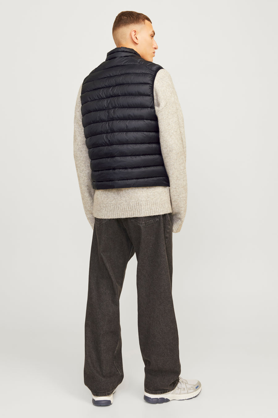 Zwart mouwloos jack van ORIGINALS BY JACK & JONES, gedragen over een gebreide trui, met een casual broek.
