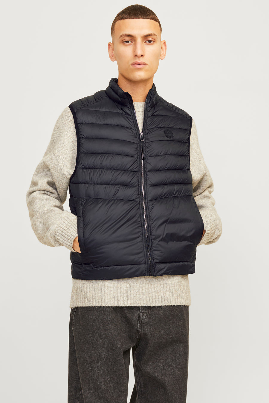 Zwart mouwloos jack van ORIGINALS BY JACK & JONES, gedragen met een gebreide trui en donkere jeans.
