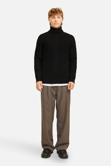 Pull à col roulé noir de JACK & JONES avec motif torsadé, porté avec un pantalon marron.
