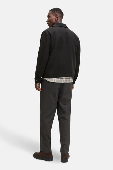 Korte bruine jas van PREMIUM by JACK & JONES met een geruite voering, gedragen met een donkere broek en bruine schoenen.