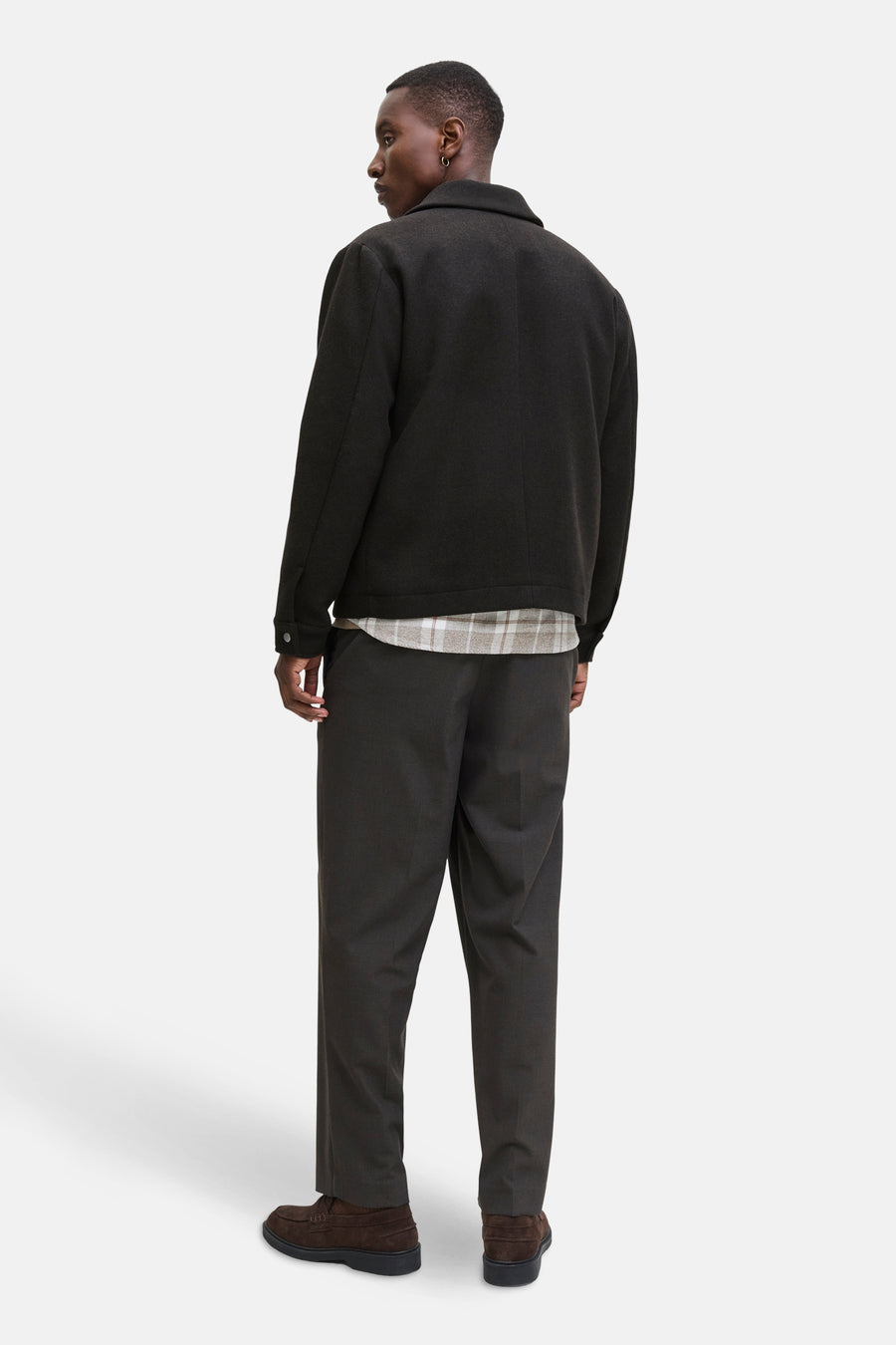 Korte bruine jas van PREMIUM by JACK & JONES met een geruite voering, gedragen met een donkere broek en bruine schoenen.