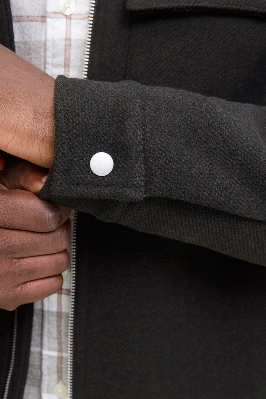 Korte bruine jas van PREMIUM by JACK & JONES, met witte knoop op de mouw en ritssluiting.