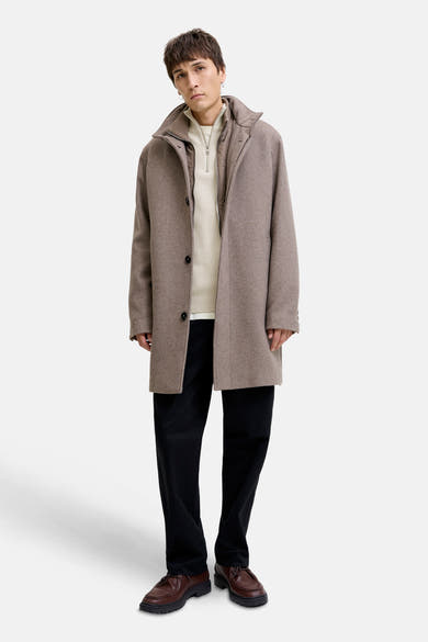 Witte coltrui van PREMIUM by JACK & JONES, gedragen onder een bruine wollen jas.