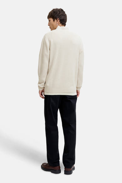 Witte coltrui van Premium by Jack & Jones, gedragen met een zwarte broek en bruine schoenen, van achteren gezien.