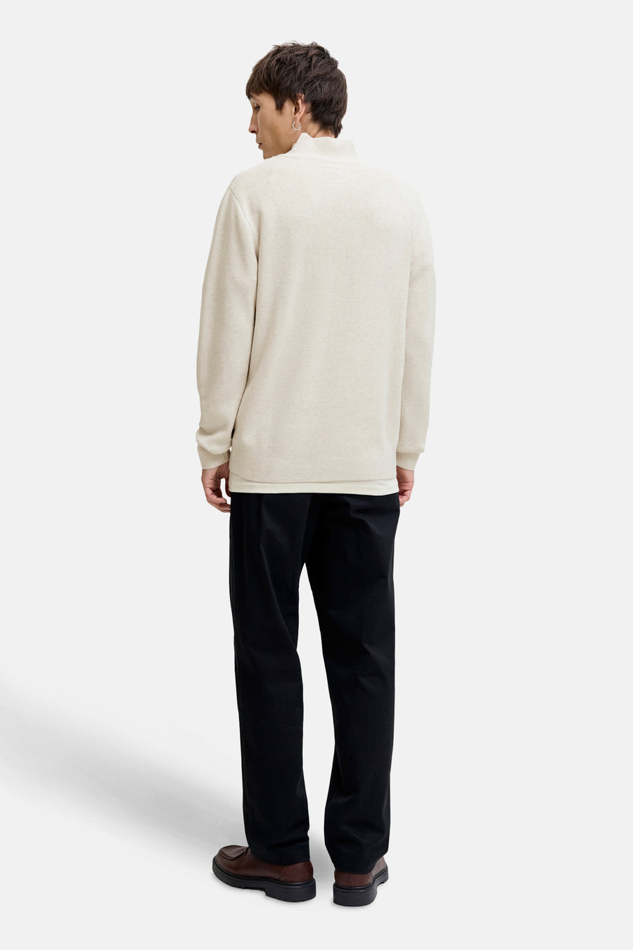 Witte coltrui van Premium by Jack & Jones, gedragen met een zwarte broek en bruine schoenen, van achteren gezien.