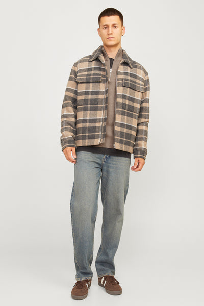 Pull à col roulé beige de PREMIUM by JACK & JONES, porté avec une chemise à carreaux et un jean décontracté.