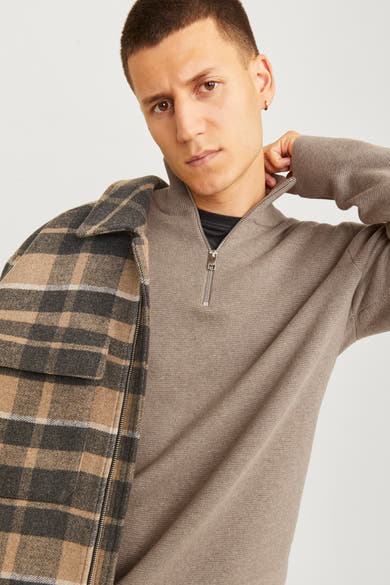Pull à col roulé beige de PREMIUM by JACK & JONES, porté avec une chemise à carreaux.