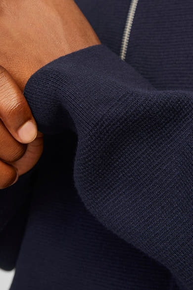 Blauwe coltrui van PREMIUM by JACK & JONES, in een getextureerde breinaalden, met een zichtbare hand.