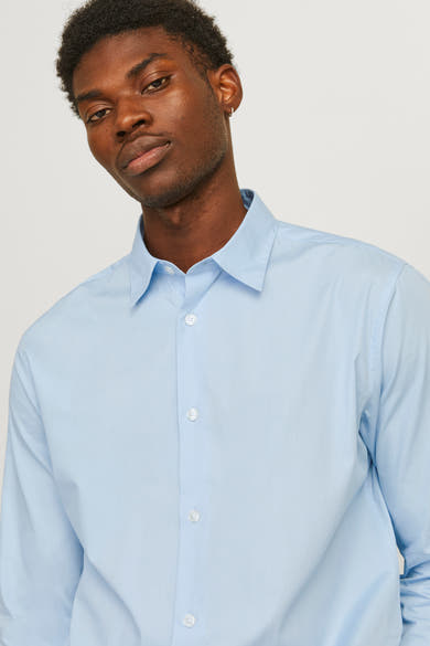 Blauw overhemd met lange mouwen van PREMIUM BY JACK & JONES, gedragen door een man met een oorbel.