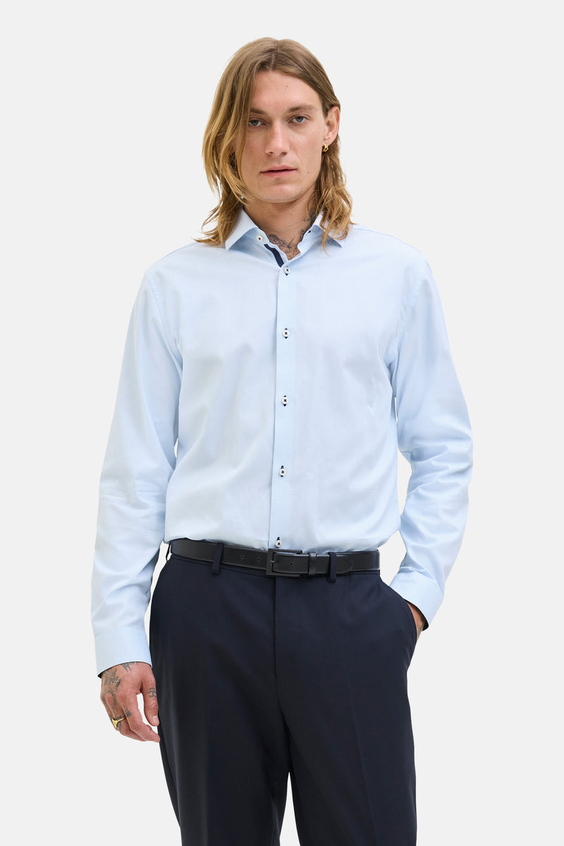Blauw overhemd met lange mouwen van PREMIUM by JACK & JONES, gedragen met een zwarte broek en een leren riem.