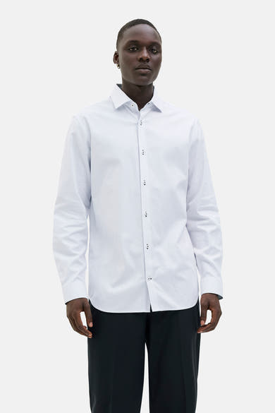 Wit overhemd met lange mouwen van PREMIUM by JACK & JONES, stippenpatroon, gedragen met een zwarte broek.