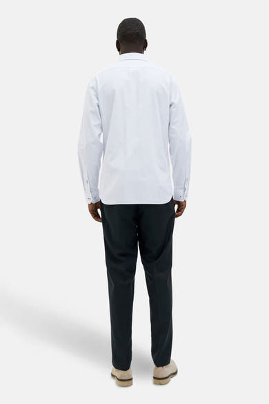 Wit overhemd met lange mouwen en stippenpatroon, van PREMIUM by JACK & JONES, gedragen met een zwarte broek en suède schoenen.