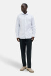 Wit overhemd met lange mouwen van PREMIUM by JACK & JONES, met subtiele verticale strepen, gedragen met een zwarte broek en suède schoenen.