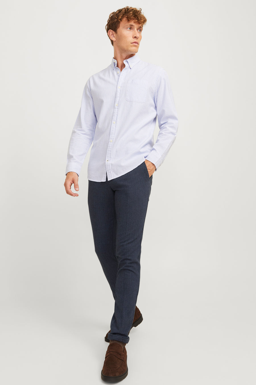 Pantalon de costume bleu marine de JACK & JONES, porté avec une chemise rayée et des chaussures marron.