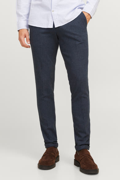 Pantalon de costume bleu de JACK & JONES, motif à chevrons et porté avec une chemise rayée.
