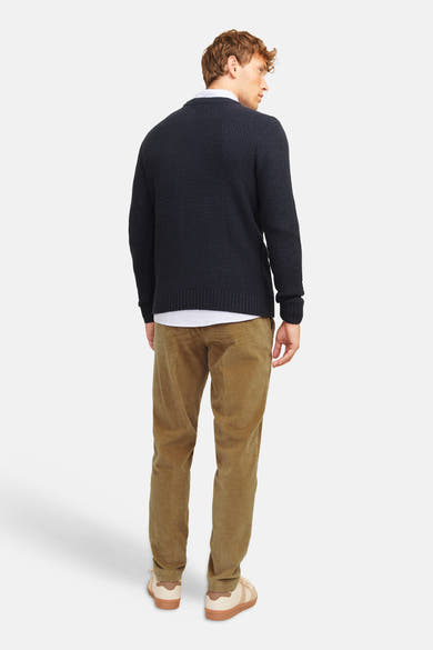 Pantalon de costume beige en velours côtelé par JACK & JONES, vue arrière sur modèle portant pull marine et baskets claires