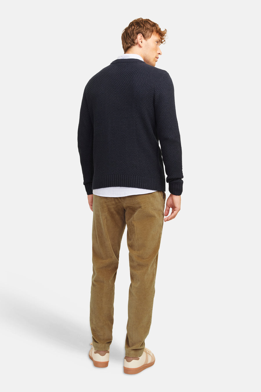 Pantalon de costume beige en velours côtelé par JACK & JONES, vue arrière sur modèle portant pull marine et baskets claires