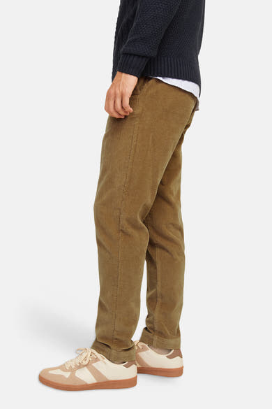 Pantalon de costume beige en velours côtelé par JACK & JONES, vue de profil, porté avec pull marine et baskets claires