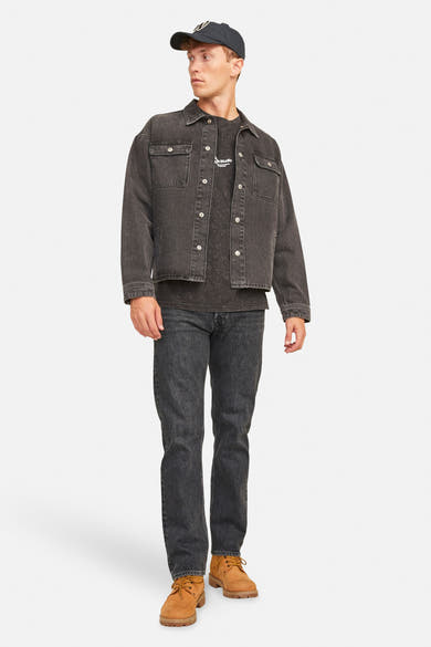 Zwarte, nauwsluitende jeans van JACK & JONES JEANS INTELLIGENCE gedragen met een grijs spijkerjack en bruine laarzen.