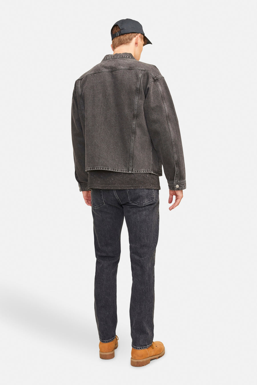 Zwarte, taps toelopende jeans van JACK & JONES JEANS INTELLIGENCE, gedragen met een zwart denim jack en bruine laarzen.