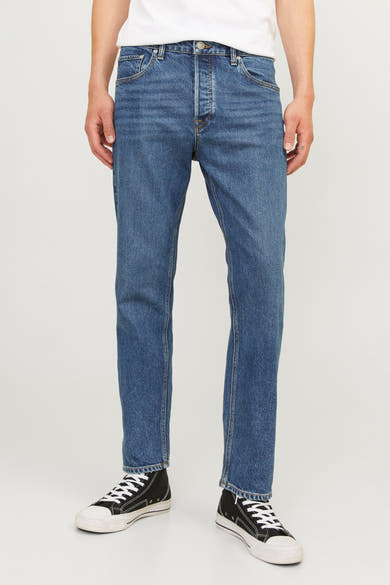 Jack & Jones Intelligence middellange blauwe tapered jeans met een wit overhemd en zwarte schoenen.