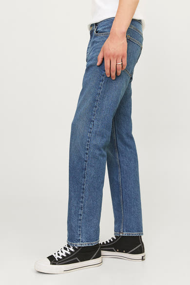 Taps toelopende jeans van middendonkerblauw denim van JACK & JONES, gedragen met zwart-witte hoge sneakers.