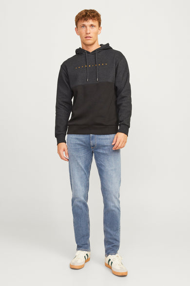 Jean droit bleu moyen de JACK & JONES, porté avec un sweat à capuche gris et noir et des baskets.
