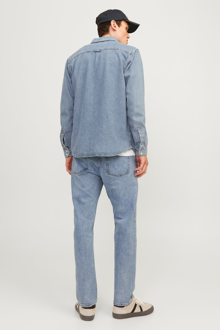 Jean fuselé bleu clair de JACK & JONES JEANS INTELLIGENCE, porté avec une chemise et une casquette.