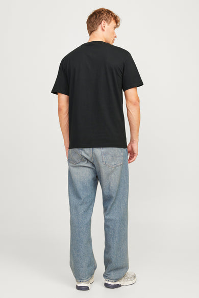 T-shirt à manches courtes noir de ORIGINALS BY JACK & JONES, porté avec un jean bleu ample et des baskets.