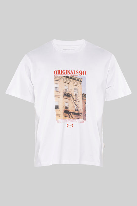 T-shirt blanc à manches courtes par ORIGINALS BY JACK & JONES avec motif immeuble urbain et lettrage rouge.
