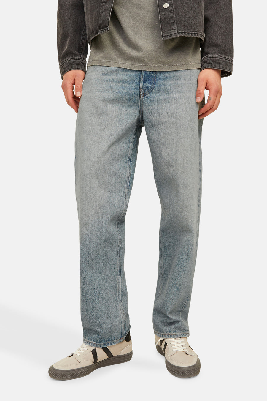 Jean large en denim bleu clair de JACK & JONES, porté avec un t-shirt gris et une veste noire.