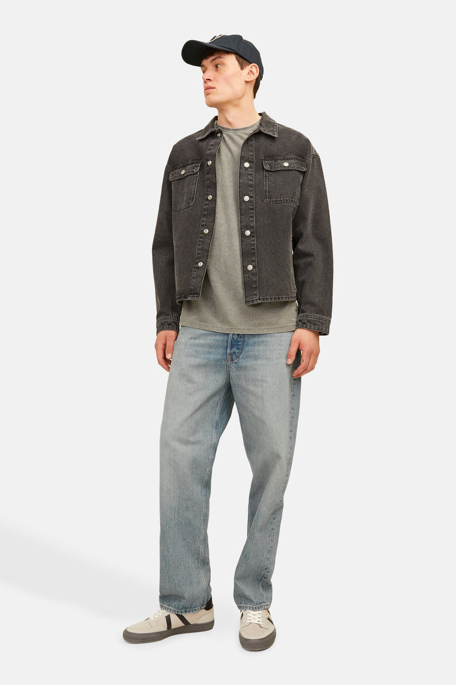 Wijde spijkerbroek in lichtblauw denim van Jack & Jones Jeans Intelligence, gedragen met een zwart jasje en beige sneakers.