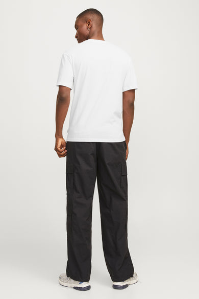 T-shirt à manches courtes blanc de JACK & JONES, porté avec un pantalon cargo noir et des baskets gris.