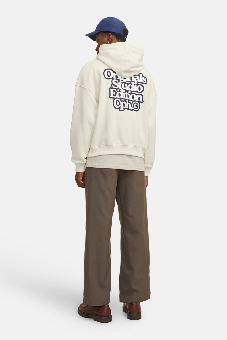 Gebroken wit hoodie van ORIGINALS BY JACK & JONES, met opdruk op de rug, gedragen met een bruine broek en schoenen.