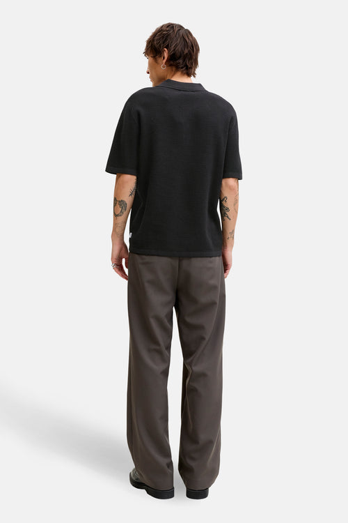 Zwarte trui van JACK & JONES, relaxed fit, gedragen met een wijde bruine broek.