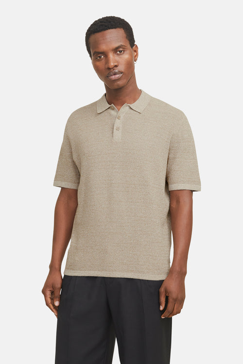 Beige T-shirt JACK & JONES, met korte mouwen, gedragen met een zwarte broek en beige sneakers.
