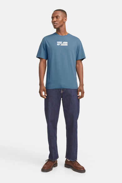 Blauwe korte mouw T-shirt van JACK & JONES, gedragen met een indigo-jean en bruine laarzen.