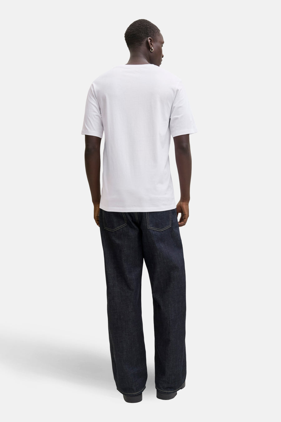 T-shirt à manches courtes blanc de JACK & JONES, porté avec un jean large bleu marine, vue de dos.