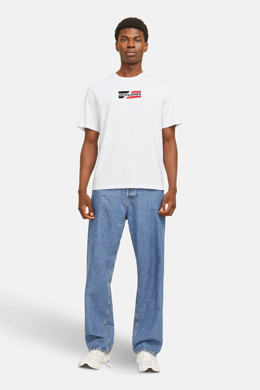 T-shirt blanc à manches courtes de JACK & JONES, porté avec un jean bleu et des chaussures de sport blanches.
