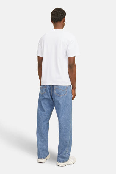 T-shirt à manches courtes blanc de JACK & JONES, porté avec un jean bleu ample et des baskets blanches, vue de dos.