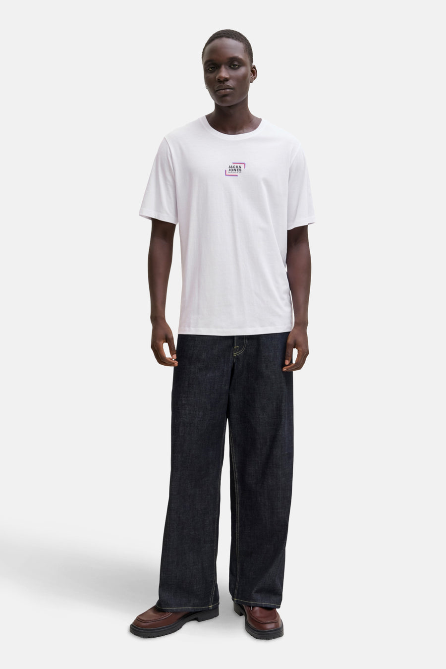 T-shirt blanc à manches courtes de JACK & JONES avec logo carré et un pantalon large foncé.