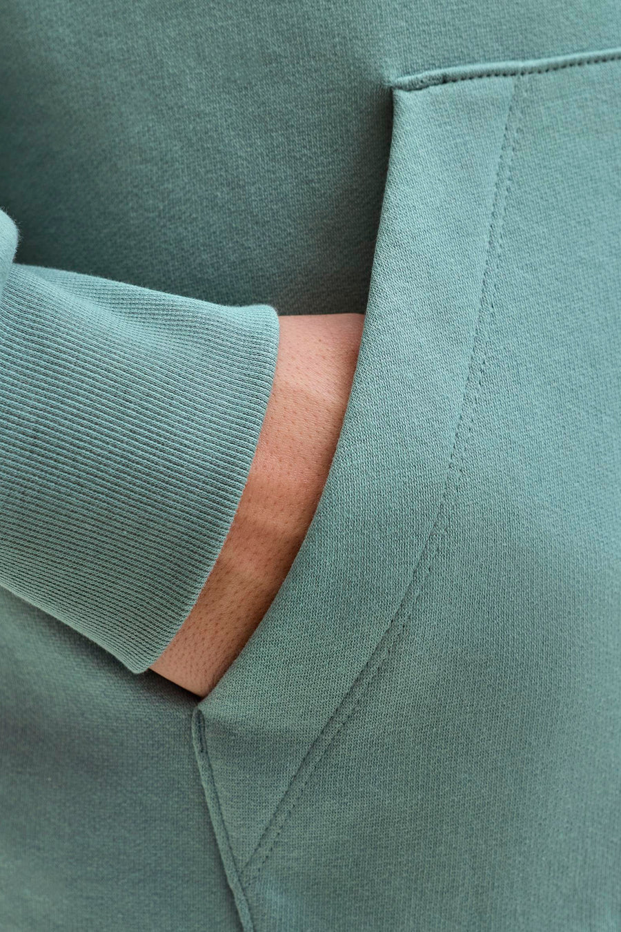 Blauwe hoodie van Jack & Jones, met één mouw en een hand in de zak.