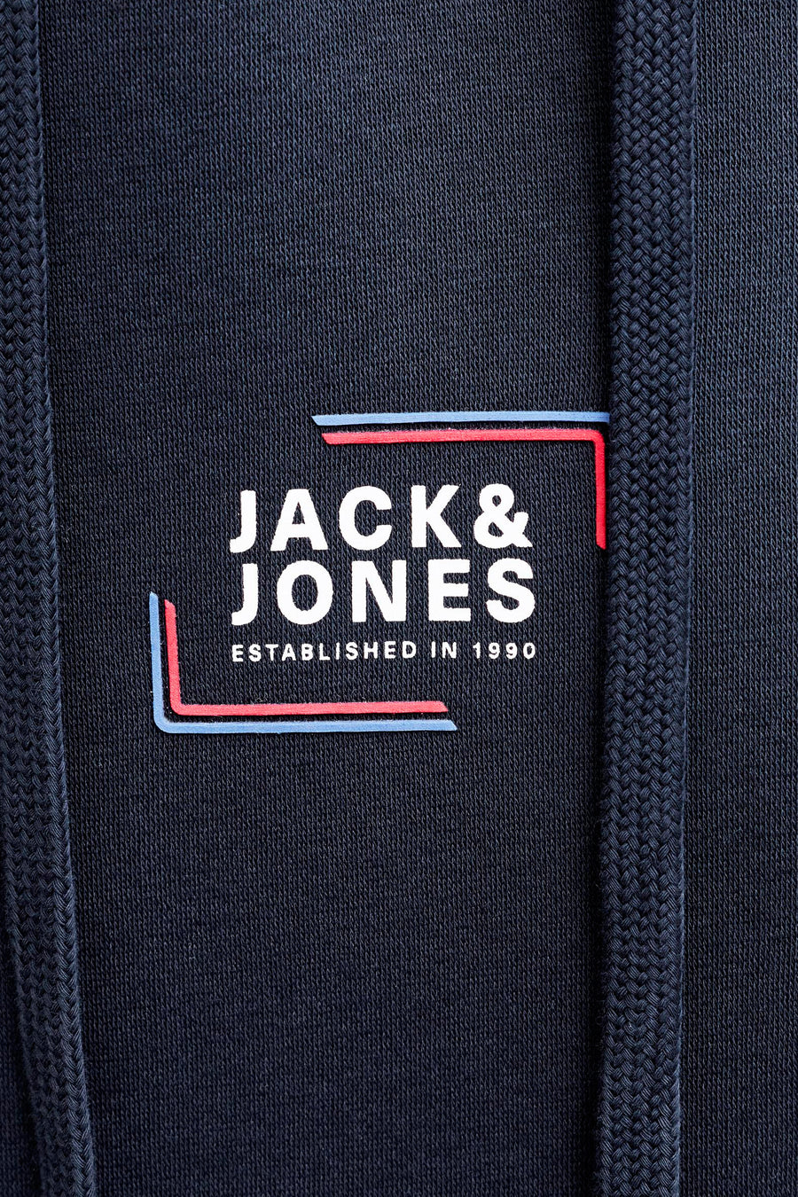 Blauwe hoodie van JACK & JONES, witte logodetail en marineblauwe trekkoorden.