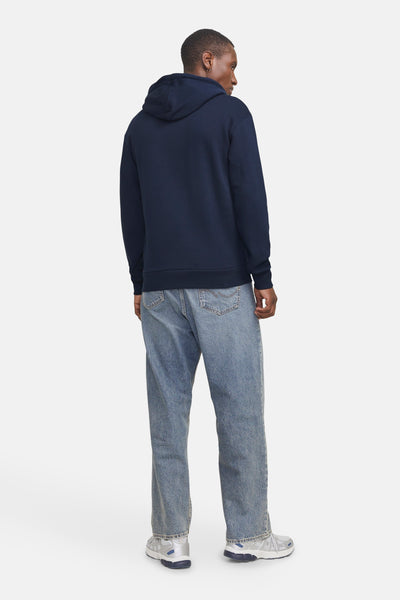 Blauwe hoodie van JACK & JONES, gedragen met een wijde jeans en zilveren sneakers.