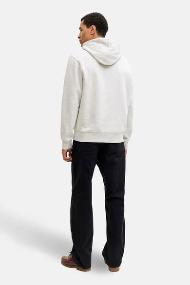 Ecru hoodie van JACK & JONES, met zwarte achterzakken van een broek en bruine schoenen