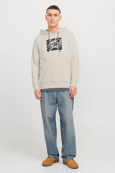 Ecru hoodie van ORIGINALS BY JACK & JONES met grafische print op de voorkant, gedragen met een grijs T-shirt en een wijde blauwe jeans.