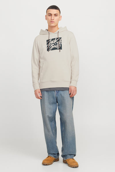 Ecru hoodie van ORIGINALS BY JACK & JONES met grafische print op de voorkant, gedragen met een grijs T-shirt en een wijde blauwe jeans.