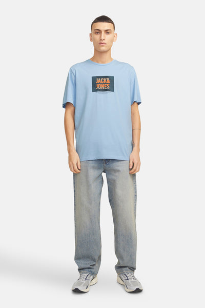 Blauwe t-shirt met korte mouwen van JACK & JONES, gedragen met een gebroken jeans en grijsen.