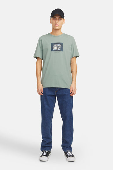 T-shirt vert à manches courtes de JACK & JONES, porté avec un jean bleu et des baskets noires.