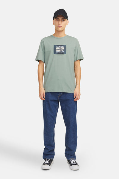 T-shirt vert à manches courtes de JACK & JONES, porté avec un jean bleu et des baskets noires.